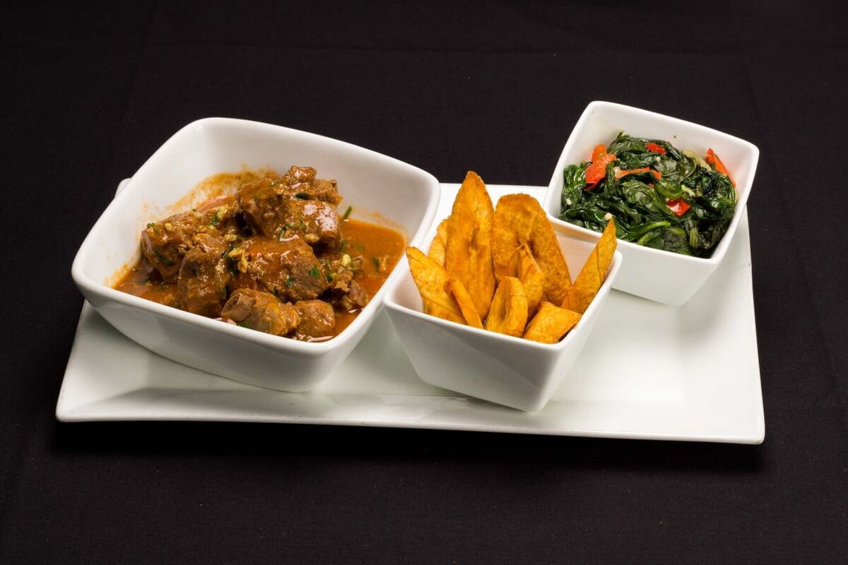 Goat Curry — slow-simmered with plantains and sautéed greens